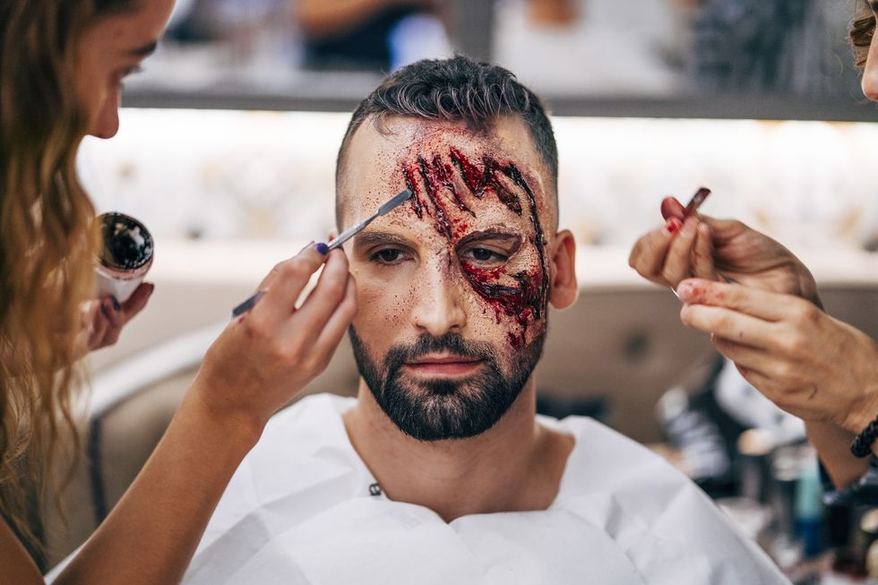 man with makeup on his face with wounds and blood.