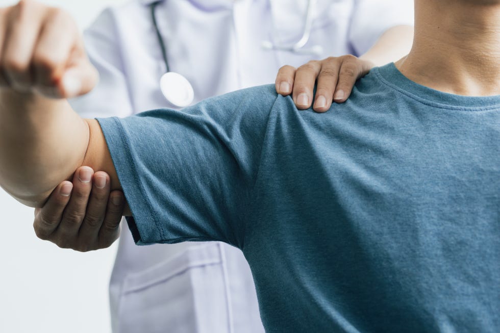 a man with shoulder pain goes to the doctor, the doctor diagnoses the patient's arm pain and shoulder pain concept of physical therapy and rehabilitation