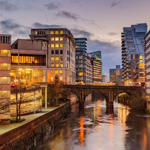 modern apartments on both side of river irwell passing through manchester city center, uk