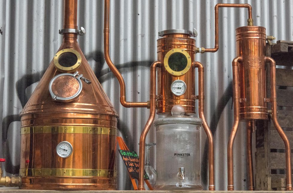 A still or distillery equipment made from copper at a gin manufacturer in central london. Micro breweries and distilling gin with basic kit and gear.