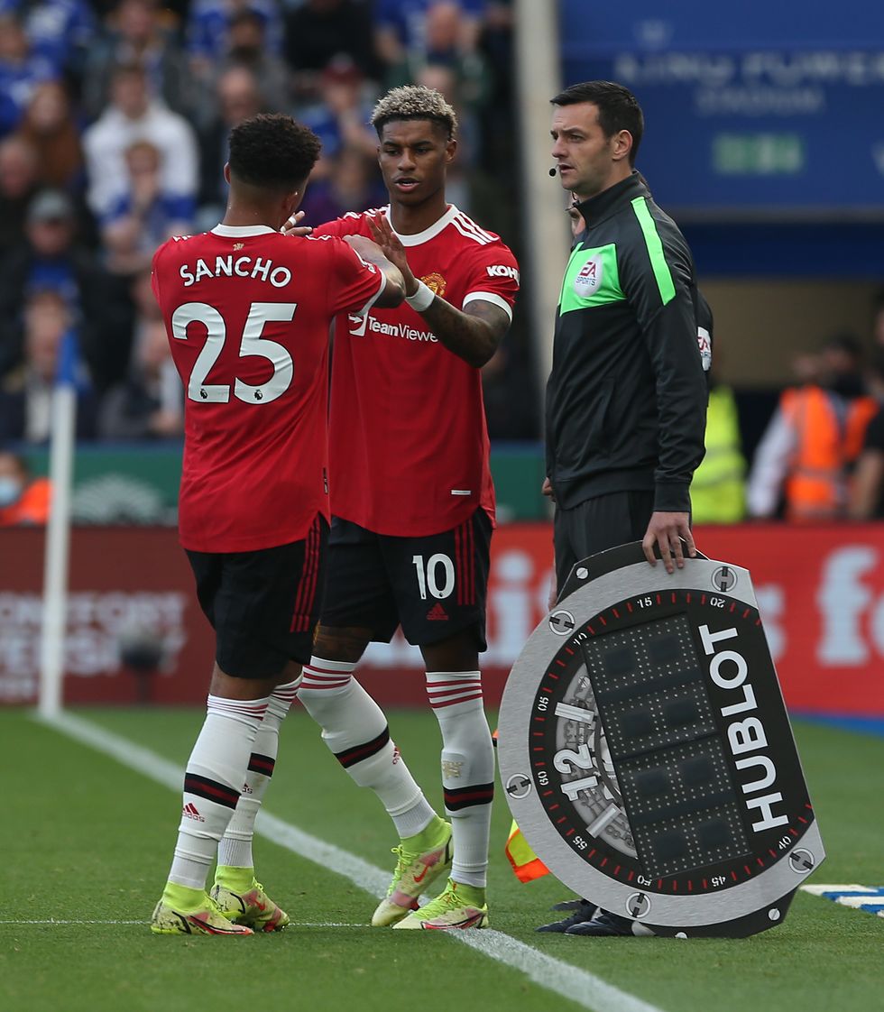 manchester united's marcus rashford and jadon sancho join hands at the touchline, as marcus swaps places with jadon during a substitution