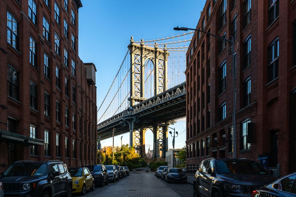 Manhattan bridge seen from a narrow alley enclosed by two brick buildings in New York, USA.