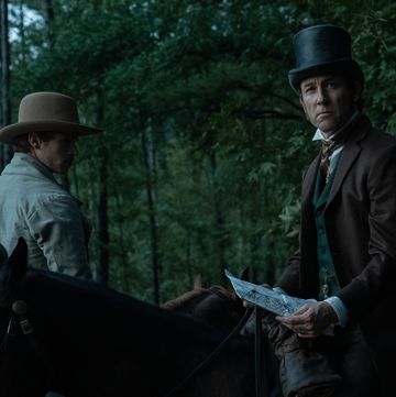 actor tobias menzies wearing a top hat and sitting on a horse portraying edwin stanton in a manhunt tv show scene