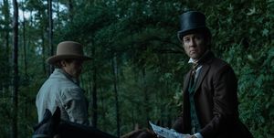 actor tobias menzies wearing a top hat and sitting on a horse portraying edwin stanton in a manhunt tv show scene