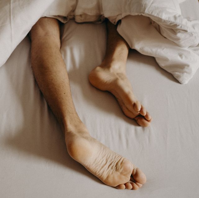 man´s feet resting in bed
