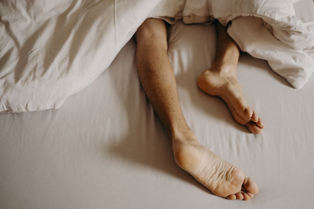 man´s feet resting in bed
