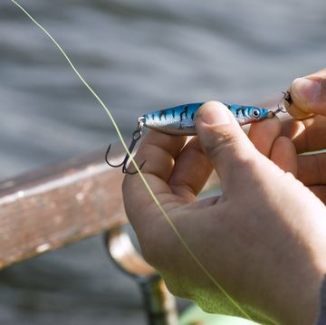 man's hand fixing bait on hook, elevated view