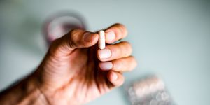 a man's hand holding a capsule  pill