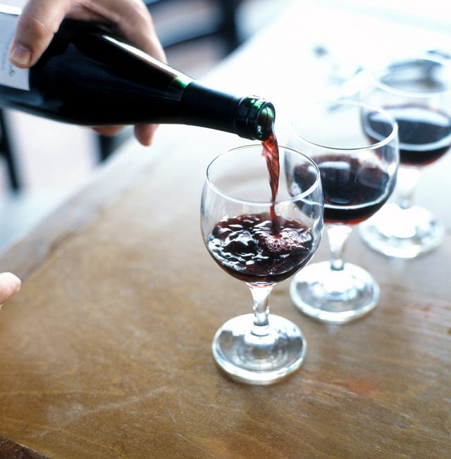 Mans hand pouring red wine