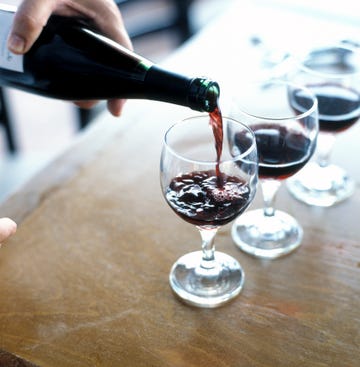 Mans hand pouring red wine
