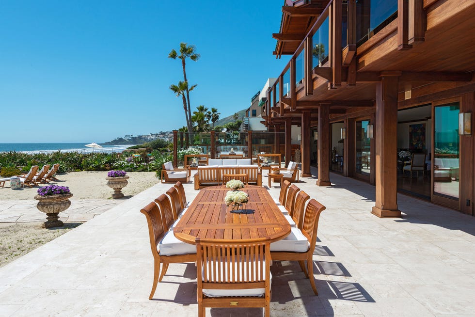 comedor exterior con mesa y sillas de madera