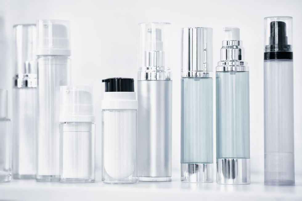 many different plastic clean transparent three blank bottles with dispenser pump for perfumes or for other liquids