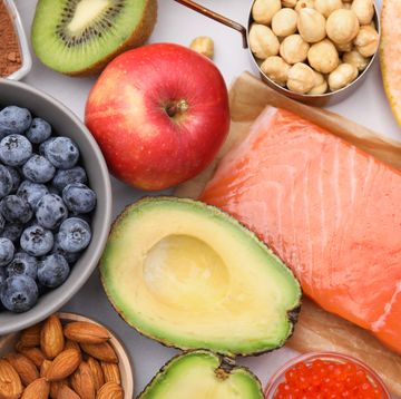 een foto van verschillende gezonde producten, zoals een appel, avocado, blauwe bessen en zalm