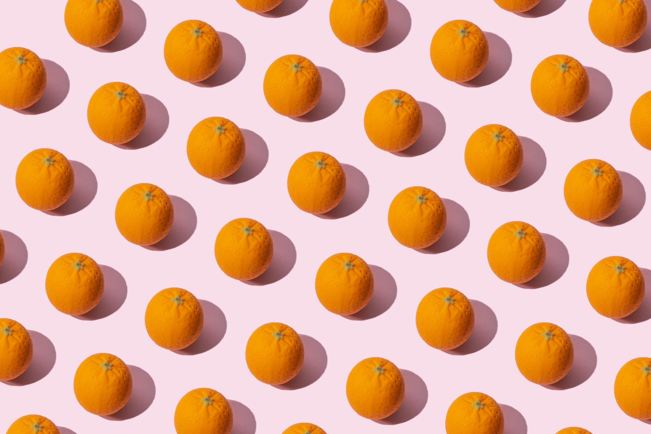 many oranges on pink colored background