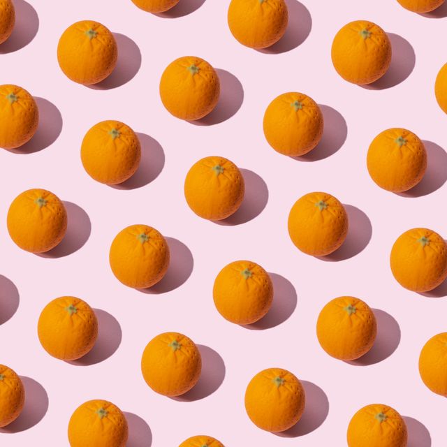 many oranges on pink colored background