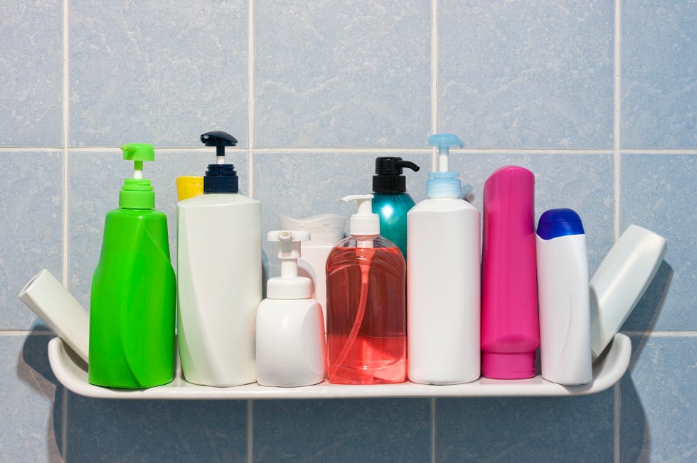 many shampoo and soap bottles on a bathroom shelf