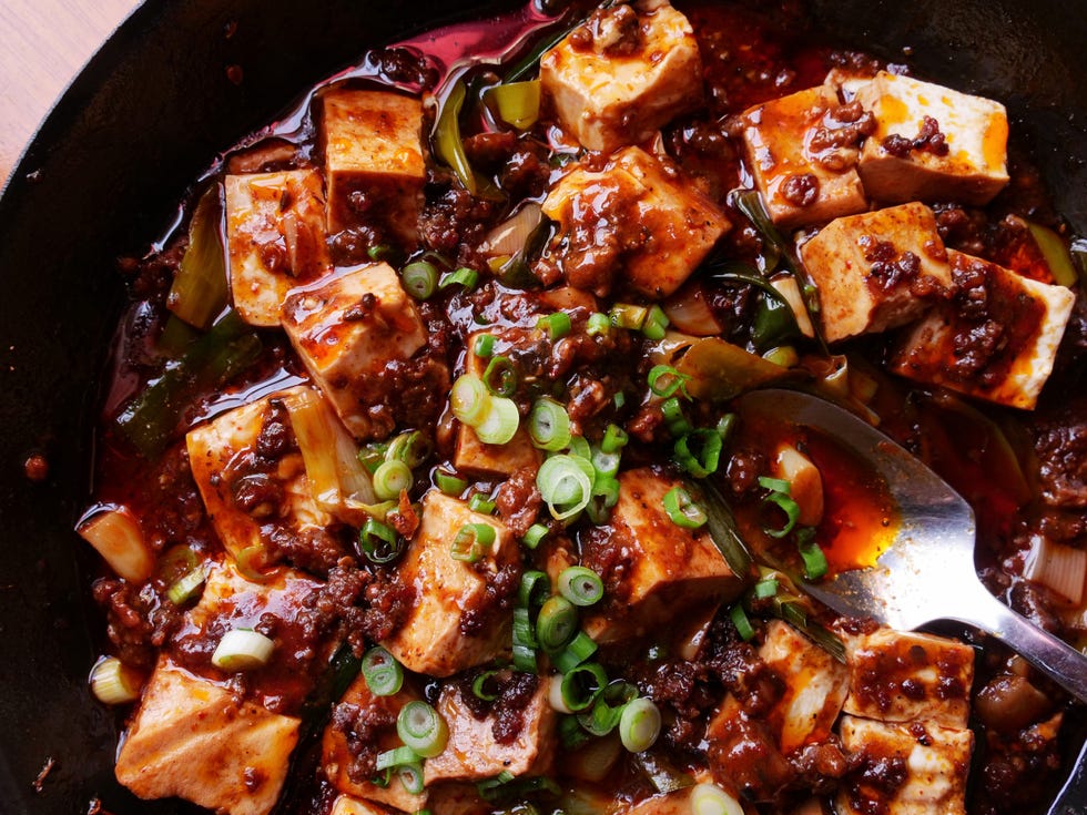 red oil surrounds shiny cubes of flavorful soft tofu sprinkled with sesame and scallions