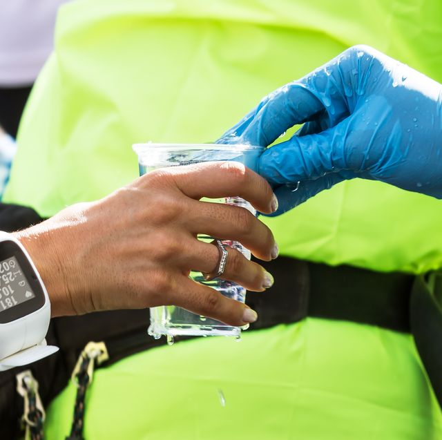 marathon runner reaches for drink cup