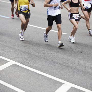 marathon runners on road, low section