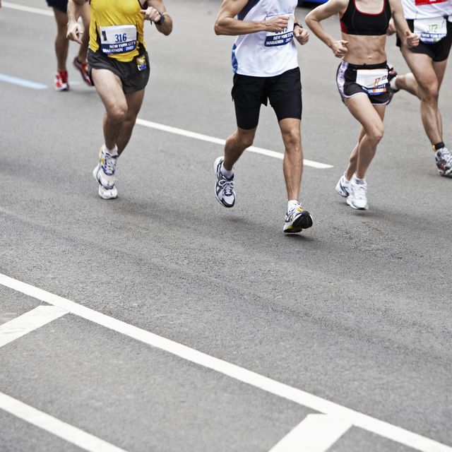 marathon runners on road, low section