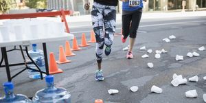 Marathon runners rounding corner with paper cups on street