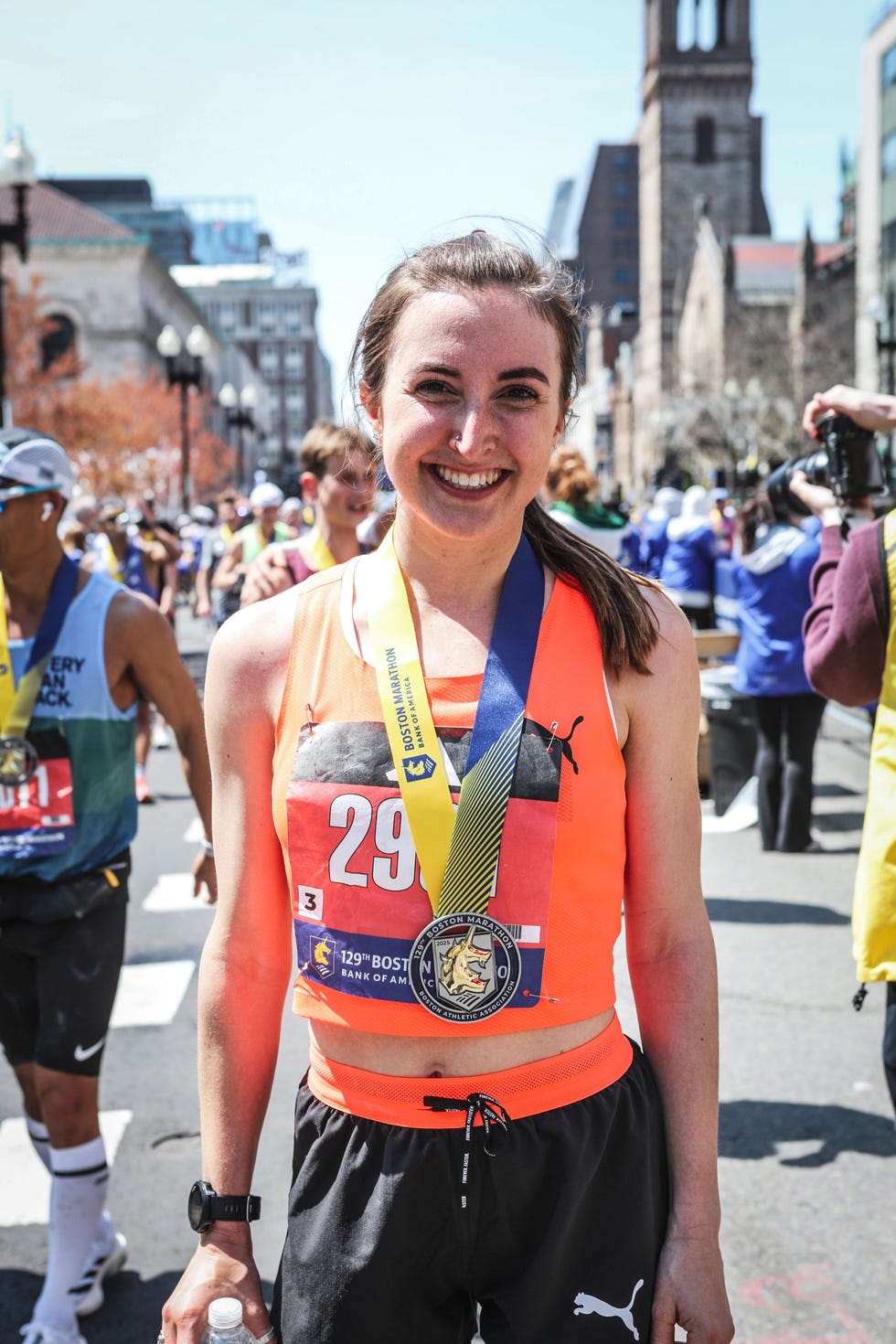 smiling runner wearing a medal after completing the 2025 boston marathon