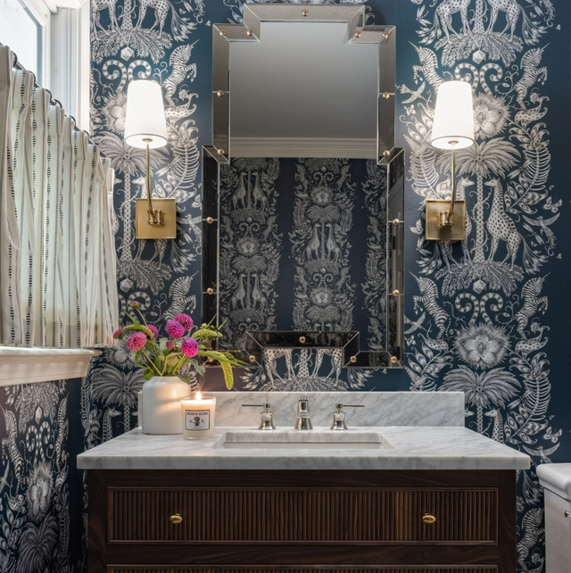 marble bathroom countertop by lindsey black interiors with elaborate teal blue wallpaper and a reeded wooden cabinet