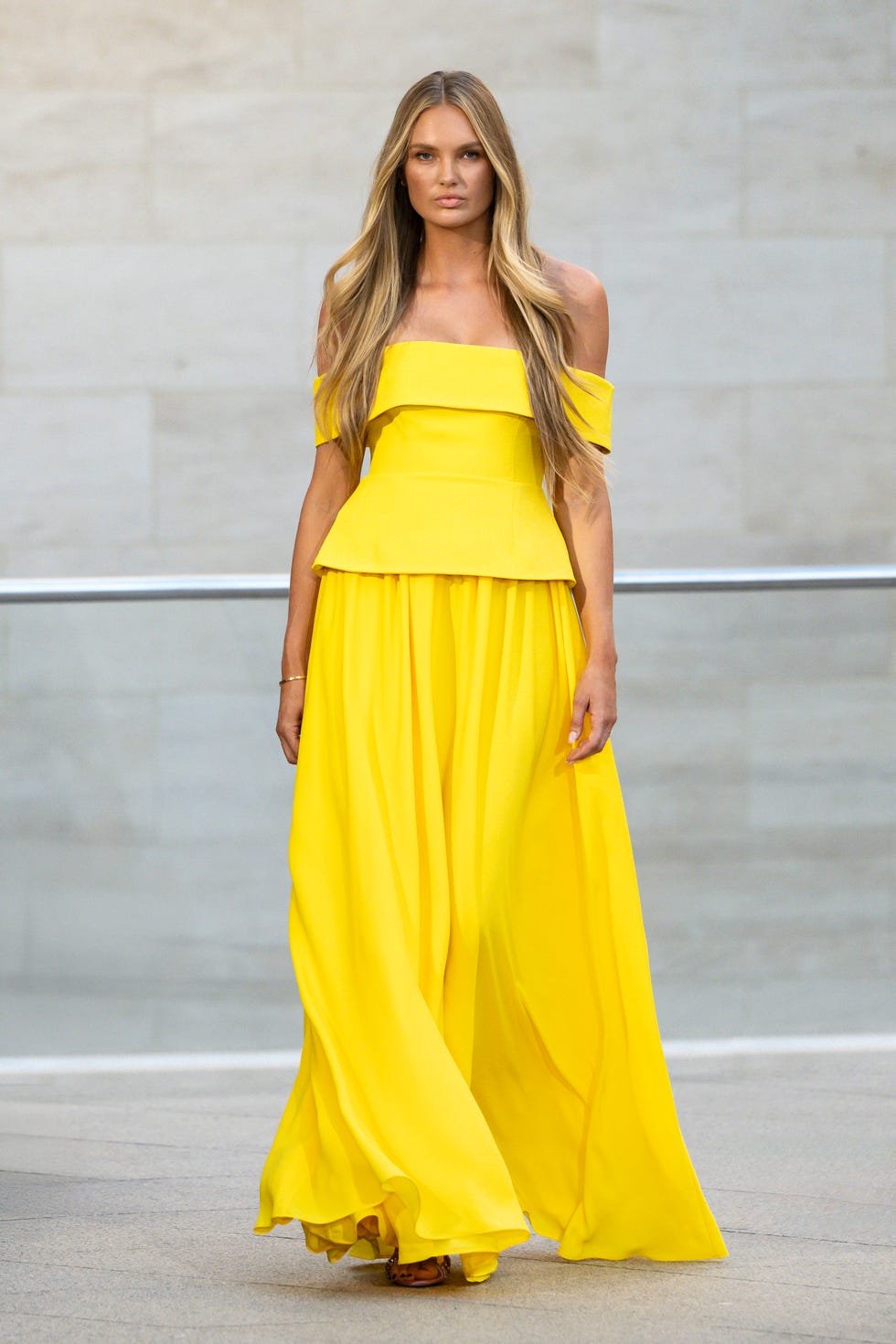 A model wearing a bright yellow yellow dress