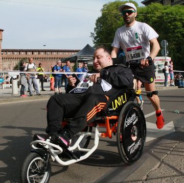 a man in a wheelchair running with a man in a wheelchair