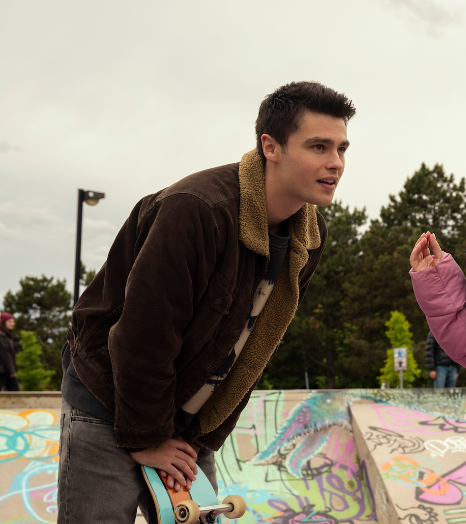 skateboarder interacting with another person at a skate park