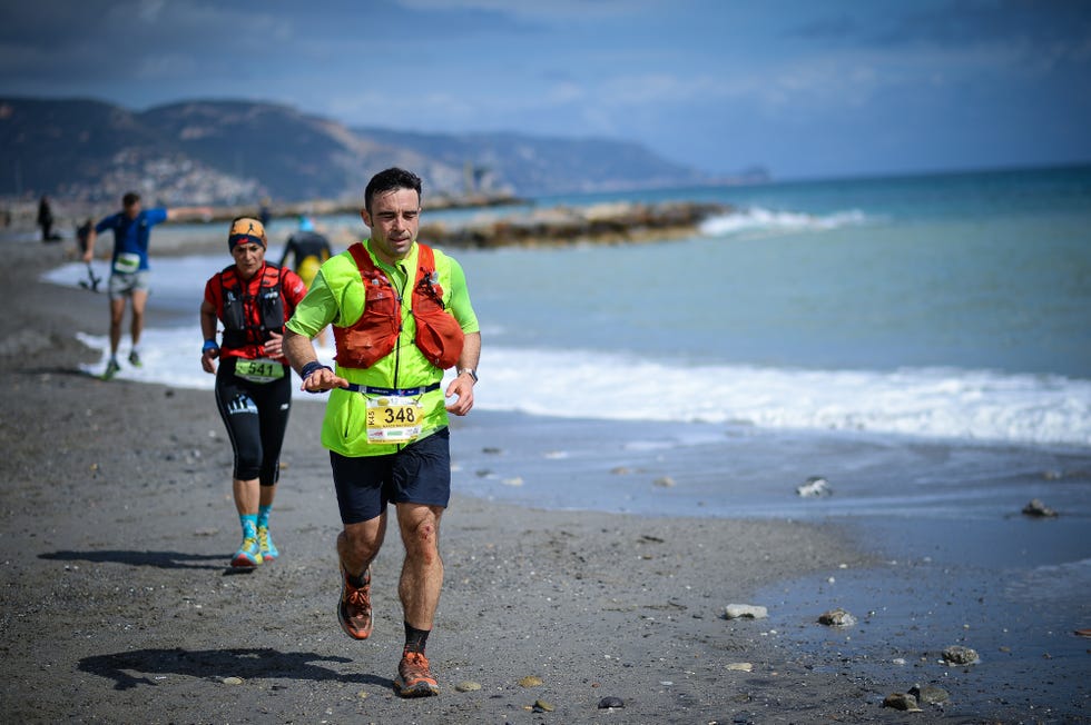 a group of people running on a beach