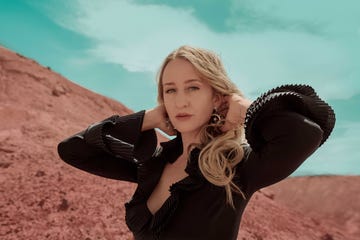 margo price stands in front of a red sand mountain