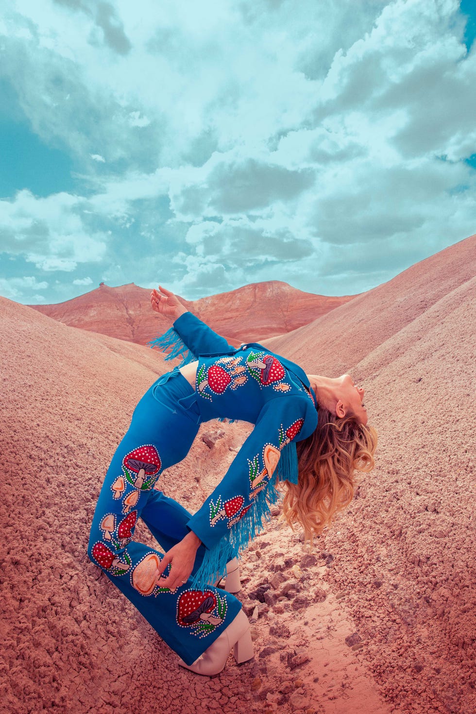 margo price wears a suit embroidered with mushrooms on a red mountain