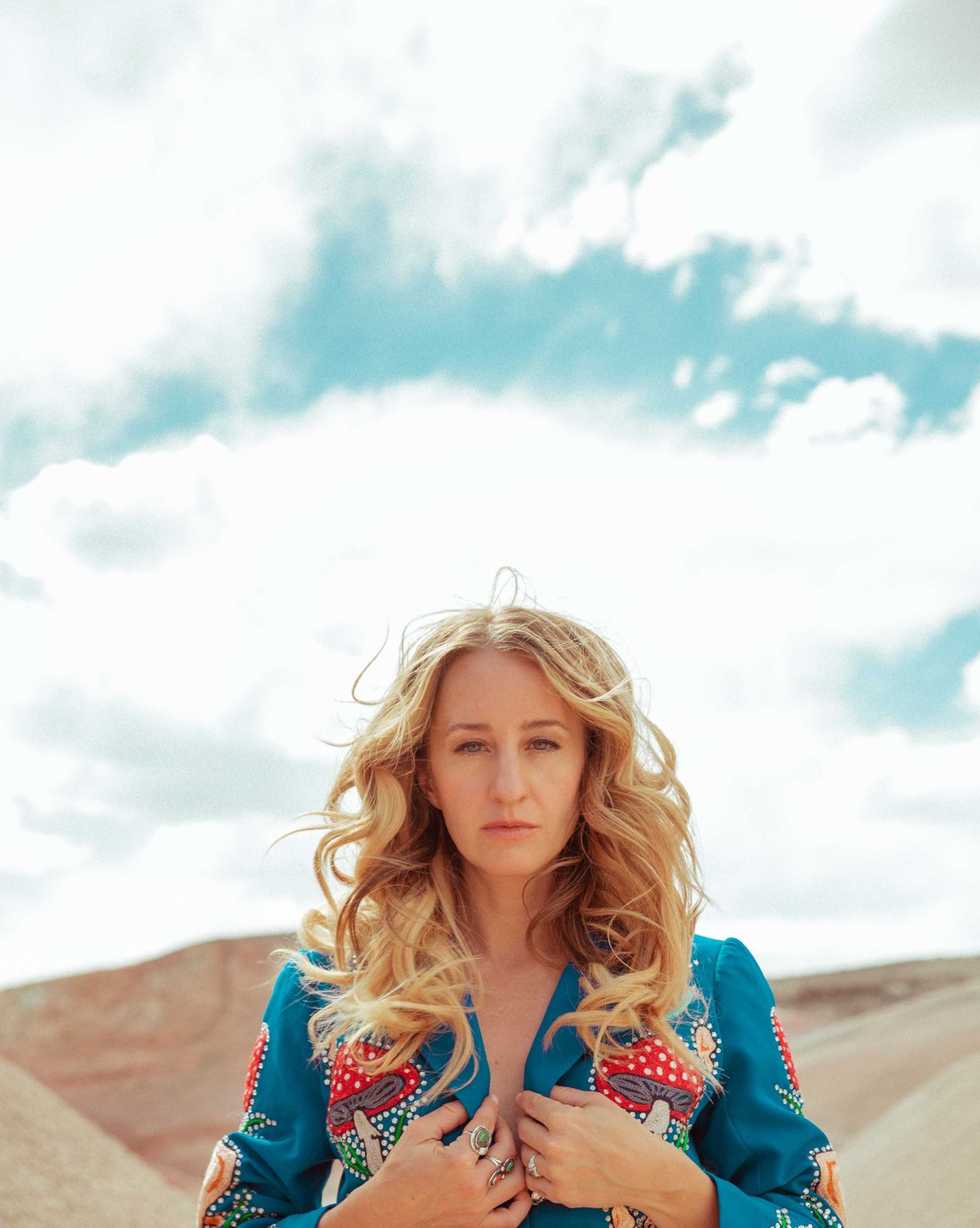 margo price wears a suit with tassles on the sleeves and mushroom embroidery