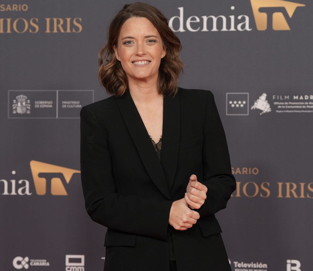 la presentadora, presidenta de la academia de television, con un traje pantalon negro