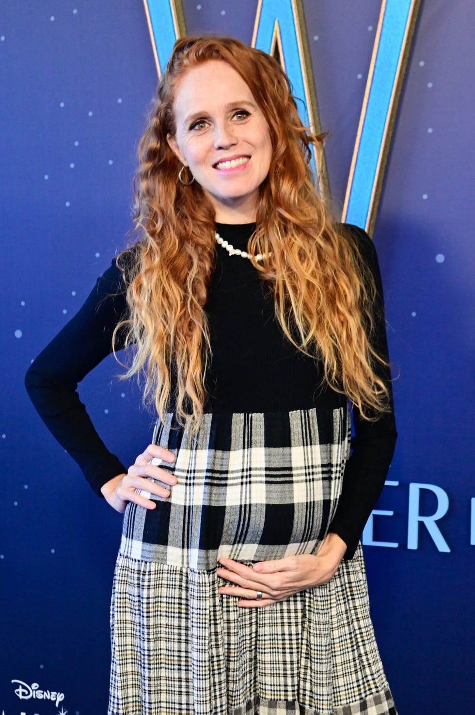 la actriz con un vestido negro y con cuadros embarazada de su tercera hija