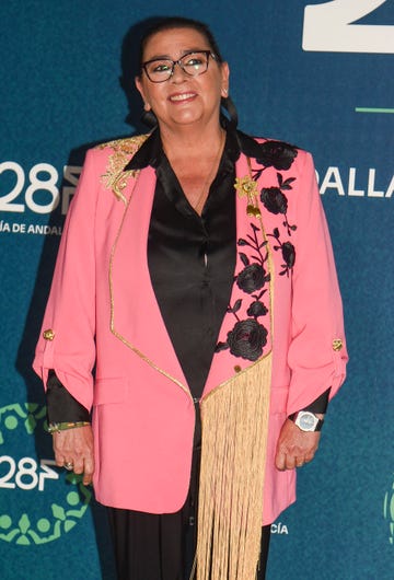 la cantante con una chaqueta rosa con detalles de flores y flecos