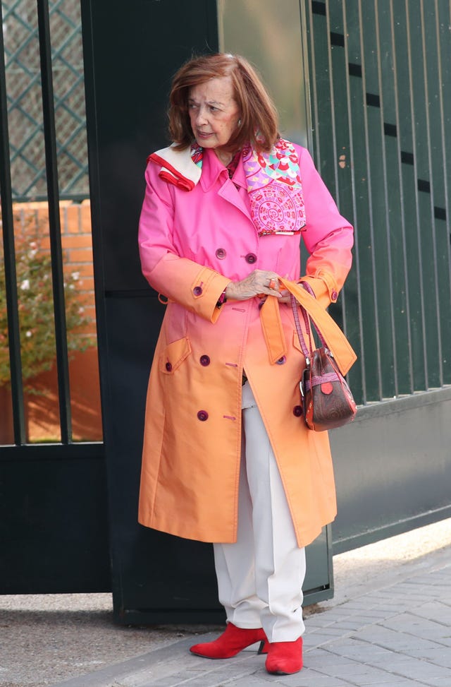 la periodista con una gabardina fucsia y naranja