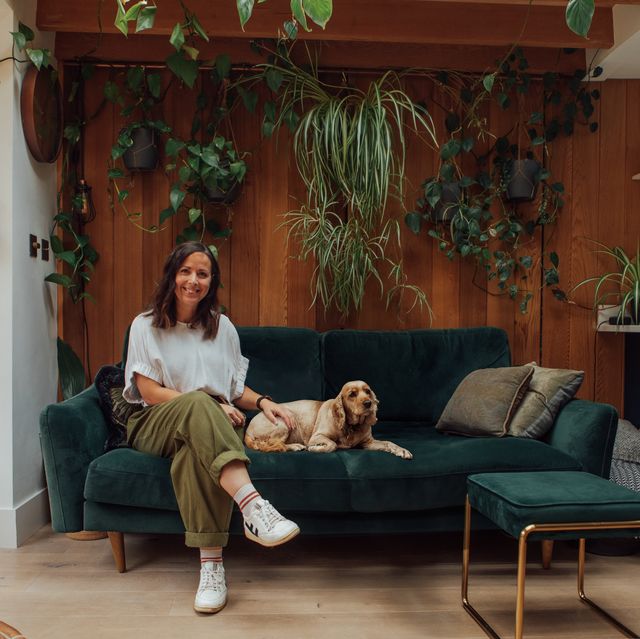 house plant expert marianna popejoy sitting on a green sofa with her dog