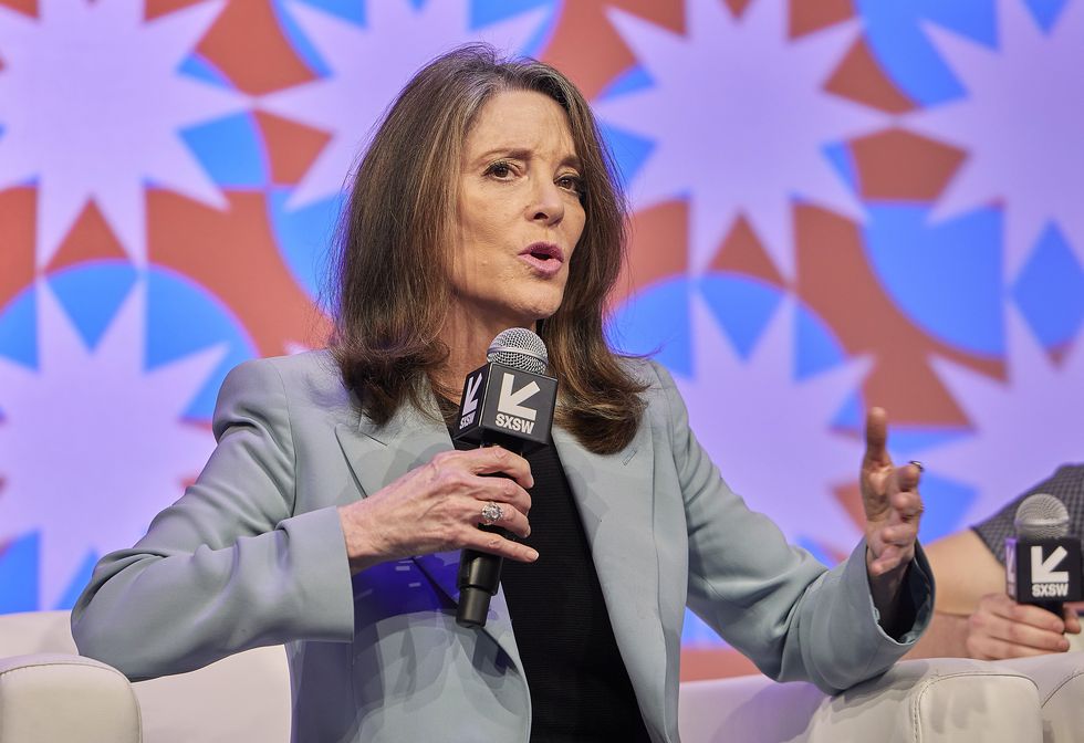marianne williamson speaks to audience while holding microphone at sxsw