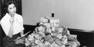 bank employee sitting by a million dollars in cash