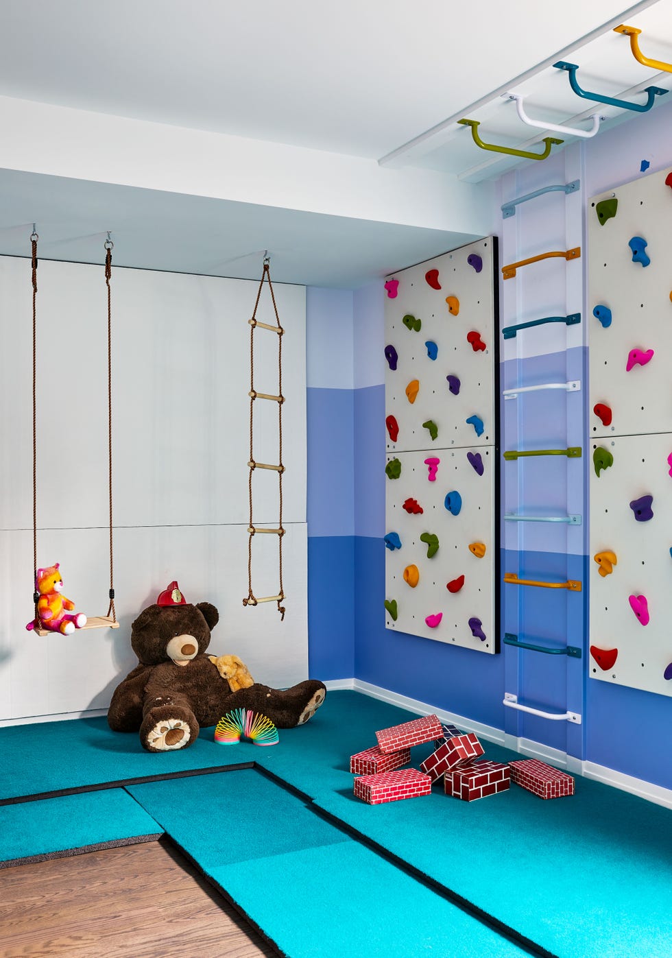 a room with a bed and a blue wall with a stuffed animal