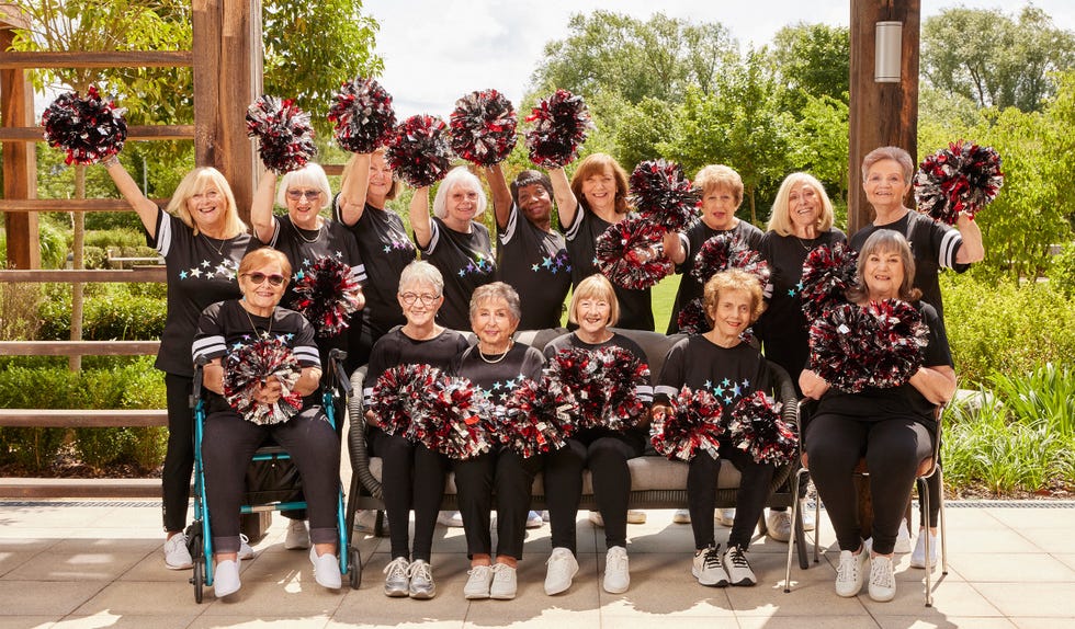 cheerleading team posing with pompoms in a lush outdoor setting