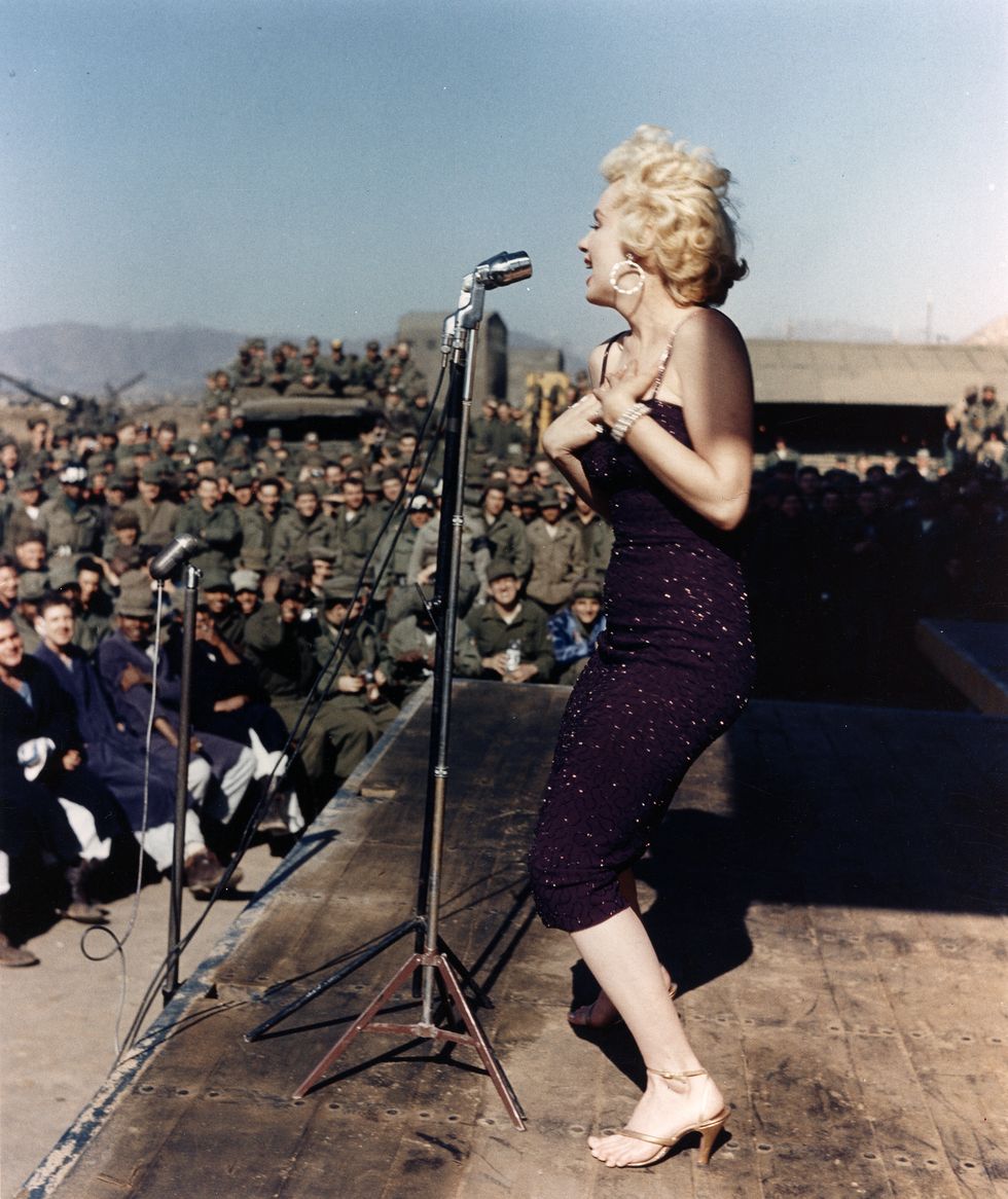 Marilyn Monroe Photo Gallery: Marilyn performing for American servicemen in Korea in February of 1954. She and DiMaggio had just arrived in Japan for their honeymoon when she was asked to perform for the troops, which she did, much to the dismay of her new groom. (Photo by Michael Ochs Archives/Getty Images)
