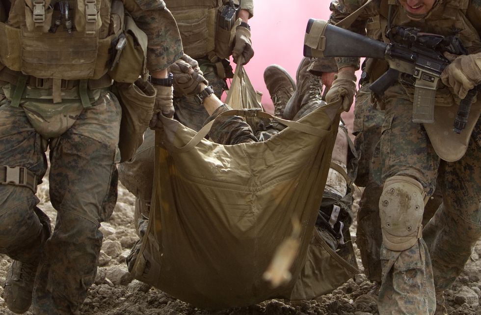 US Marines carry a wounded comrade, who