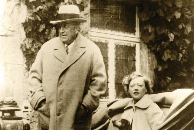 marion davies and william randolph hearst in bad nauheim, germany, davies’s pet dachshund peeks his nose out from her coat