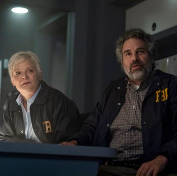 two individuals in fbi jackets seated at a table in a dimly lit room two individuals in fbi jackets seated at a table in a dimly lit room