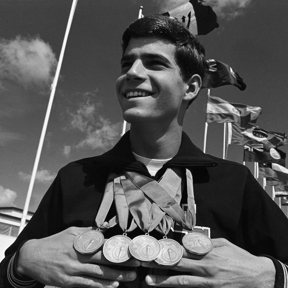 mark spitz displaying five gold medals