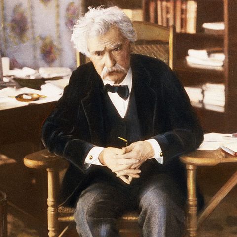 samuel clemens mark twain sits in his writing chair and appears to be concentrating intently, 1903