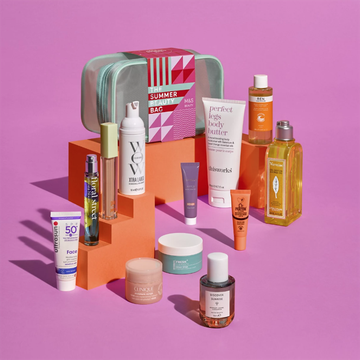 marks and spencer summer beauty bag on an orange stands with products displayed